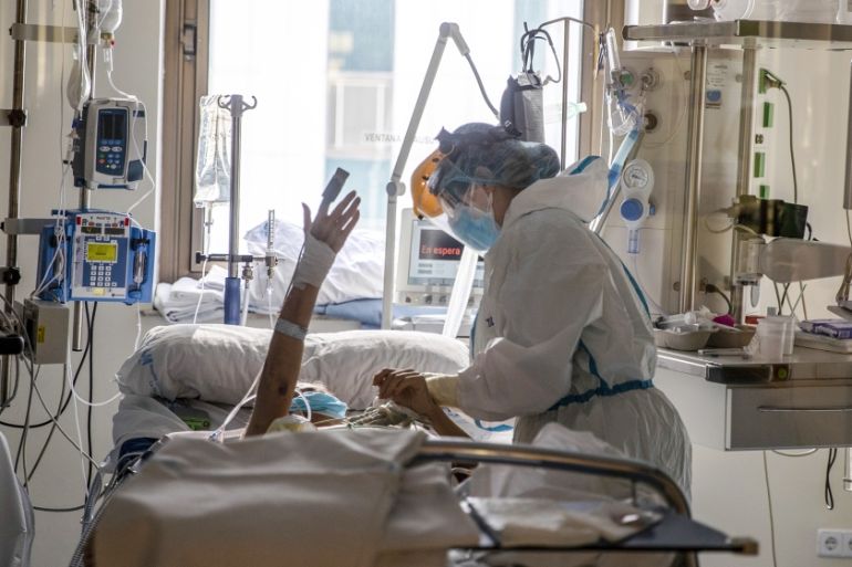 Healthcare workers assist a COVID-19 patient at one of the intensive care units (ICU) of the Ramon y Cajal hospital in Madrid, Spain, Spain, Friday, April 24, 2020. (AP Photo/Manu Fernandez)