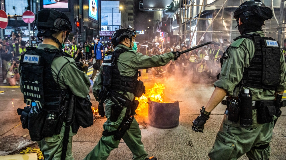 Police stand guard on a road to deter pro-democracy protesters from blocking roads in the Mong Kok district of Hong Kong on May 27, 2020, as the city’s legislature debates over a law that bans insulti
