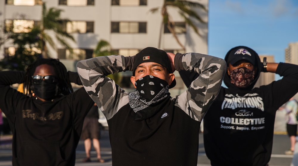 Demonstrators put their hands behind their heads as they stand in front of San Diego Police in San Diego, California on May 31, 2020, to protest against the death of Minneapolis man George Floyd. Nume