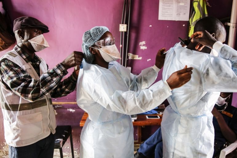 Medical staff help each other put on protective equipment before dealing with patients with non-coronavirus related issues at the Medecins Sans Frontieres (Doctors without Borders) clinic in the Matha