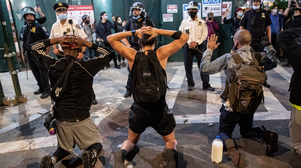 Protesters kneel in front of New York City Police during a march to honor George Floyd in Manhattan on May 31, 2020 in New York City. Protesters demonstrated for the fourth straight night after video 