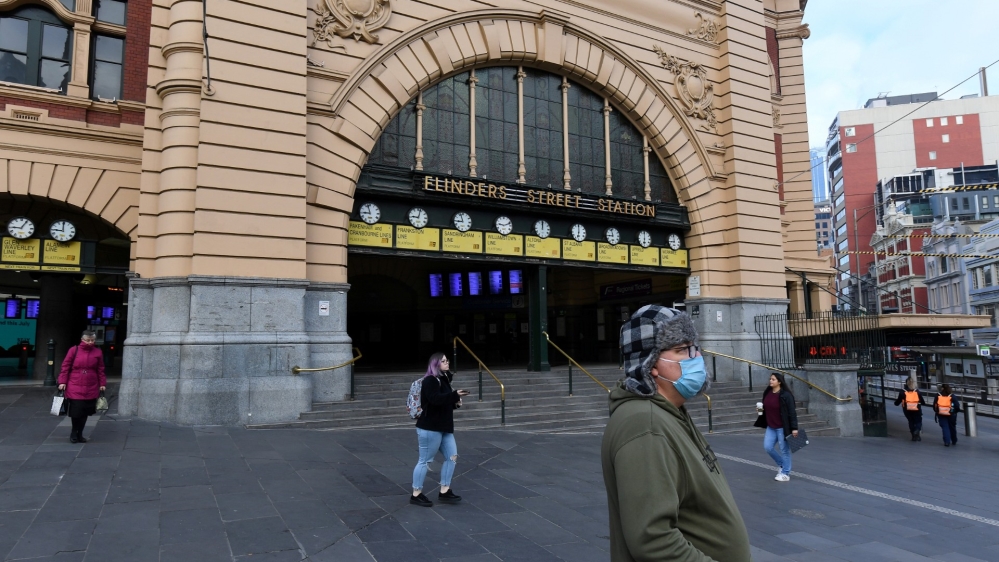 People are seen outside of Flinders Street Station during morning peak hour as the city is in lockdown in Melbourne