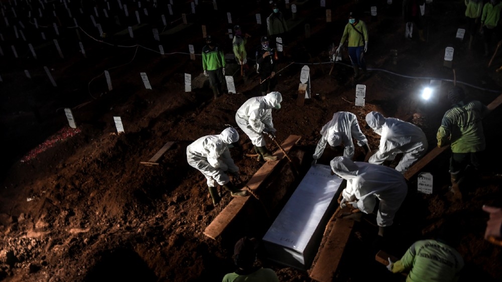 Workers wearing protective suits bury a coronavirus disease (COVID-19) victim at Pondok Ranggon cemetery complex in Jakarta, Indonesia, September 8, 2020 in this photo taken by Antara Foto. 