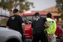 US Immigration and Customs Enforcement (ICE) officers detain a man during an operation in Escondido, California on July 8, 2019 [File: AP/Gregory Bull]