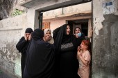 Relatives of Hoda Al-Khozondar, who was killed in an Israeli airstrike, react as mourners carry her body out of the family home, during her funeral in town of Khan Younis, southern Gaza Strip, Thursday, May 20, 2021 [Yousef Masoud/AP]