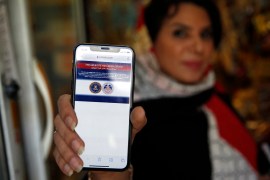 An Iranian woman shows on her mobile phone a statement declaring the website of Iran's English-language television station Press TV 'has been seized by the United Government' [AFP]