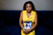 Daphne Bolton poses for a portrait holding a photograph of her brother Johnny Lorenzo Bolton, a Black man was to death by a Cobb County Sheriff's Office SWAT team member serving a search warrant last December [File: Chris Carlson/AP Photo]