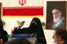 An Iranian woman casts her vote during the presidential election on Friday [Hadi Mizban/AP]