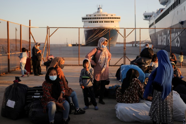 Refugees and migrants wait to be transferred to camps on the mainland after their arrival from the island of Lesbos in Greece