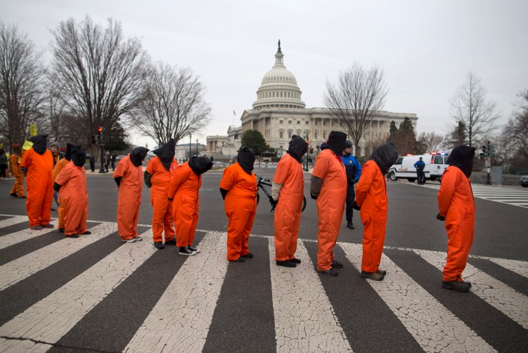 Demonstrators, dressed as Guantanamo Bay detainees, march past the Capitol building on Capitol Hill in Washington.