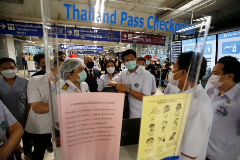 Thai deputy of Public Health Minister, Satit Pitutacha (C) talks to airport worker as visits the checkpoint for health screening protocol for international arriving passengers ?at Suvarnabhumi International Airport