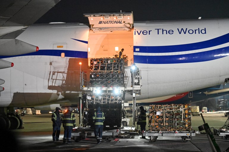 Employees unload a plane with a new US security assistance provided to Ukraine, at Kyiv's airport Boryspil