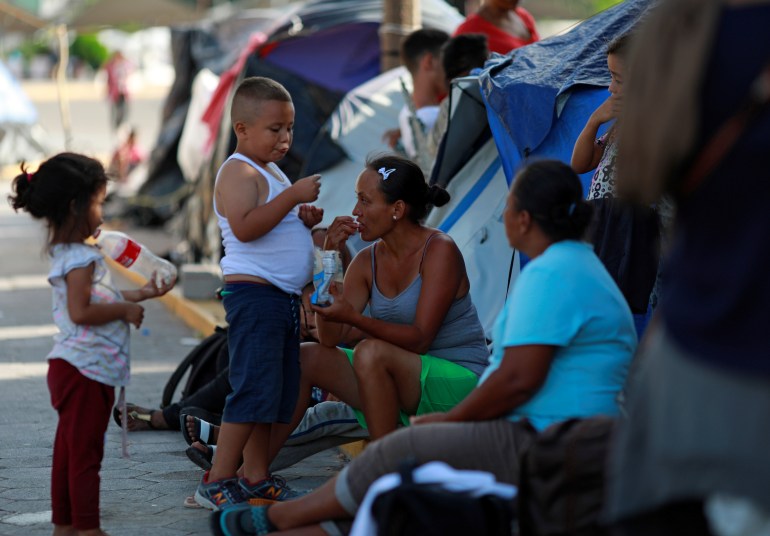 Migrant family waiting near makeshift migrant camp