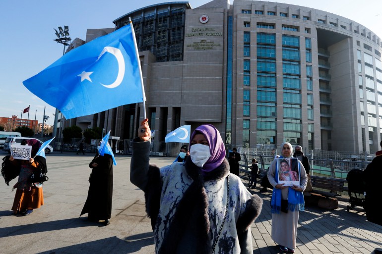 An ethnic Uighur woman waves the flag of East Turkestan outside of the courthouse in Istanbul Turkey
