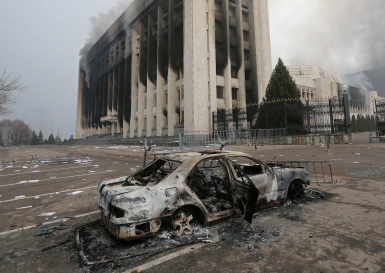 A burned car is seen in front of the mayor's office building in Almaty, Kazakhstan