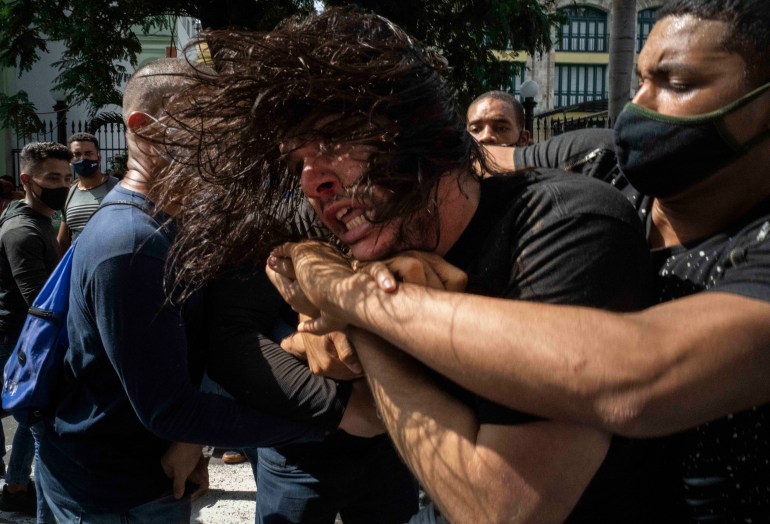 Police detaining protester in Cuba