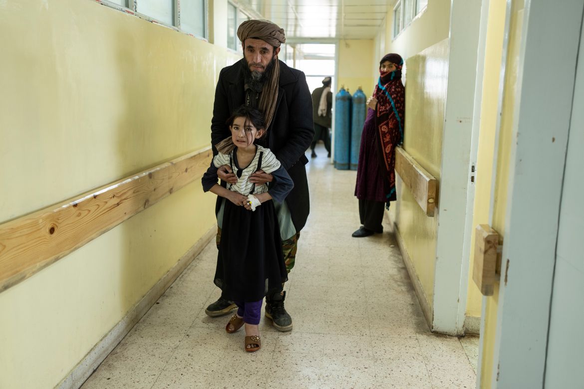 A girl walks with the help of her father in Indira Gandhi Children's Hospital in Kabul