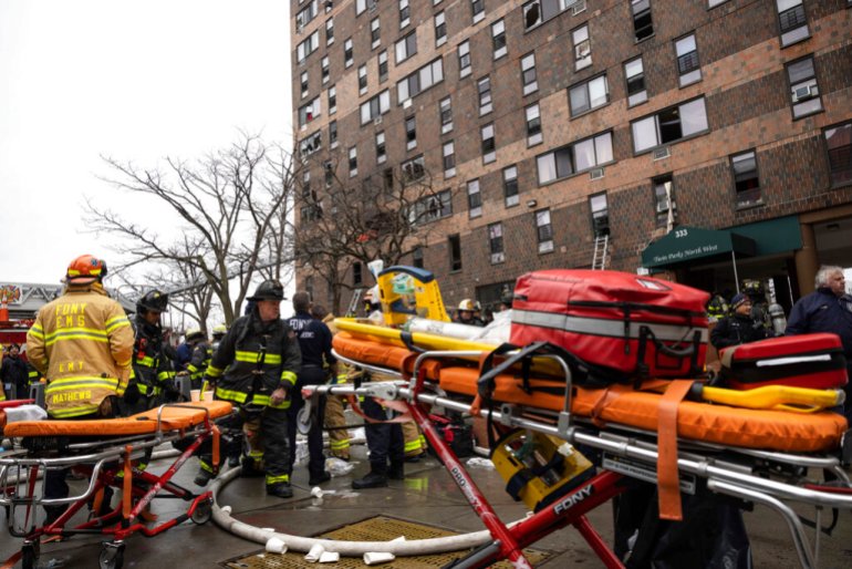 Firefighters work outside an apartment building after a fire