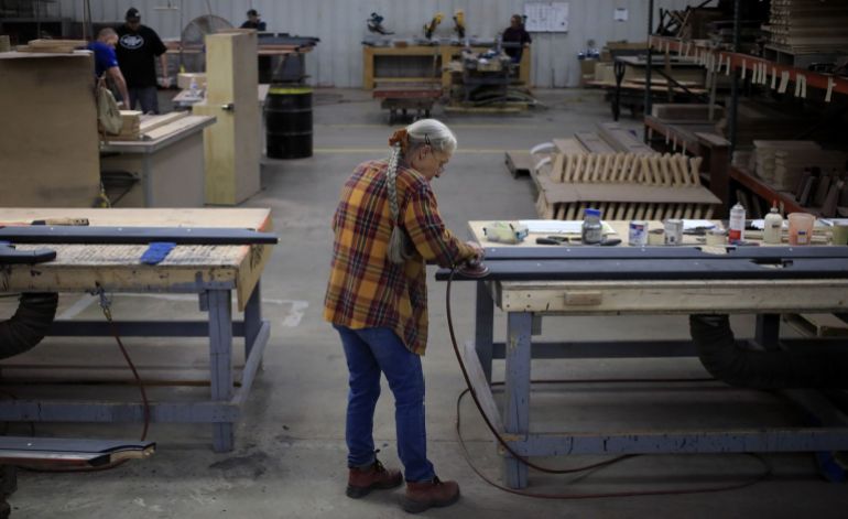 A worker sands wood components for a pool table in Jeffersonville, Indiana
