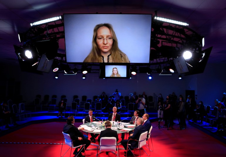 Katerina Tikhonova, with long blonde hair, seen on a large screen at a conference in St Petersburg last year 