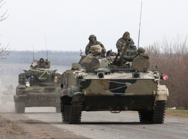 Service members of pro-Russian troops drive armoured vehicles during Ukraine-Russia conflict on a road outside the southern port city of Mariupol,