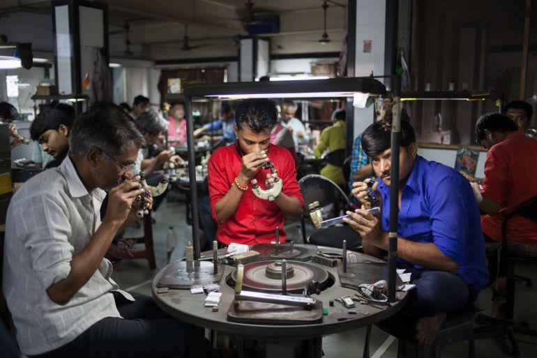 Employees inspect diamonds at a gems workshop in Surat, Gujarat, India