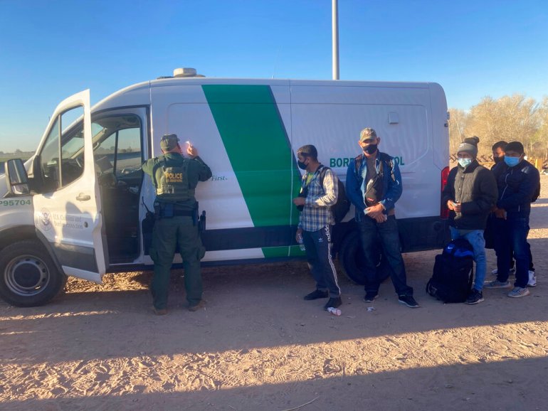 A Border Patrol agent fills out paperwork for migrants who surrendered in Yuma, Arizona