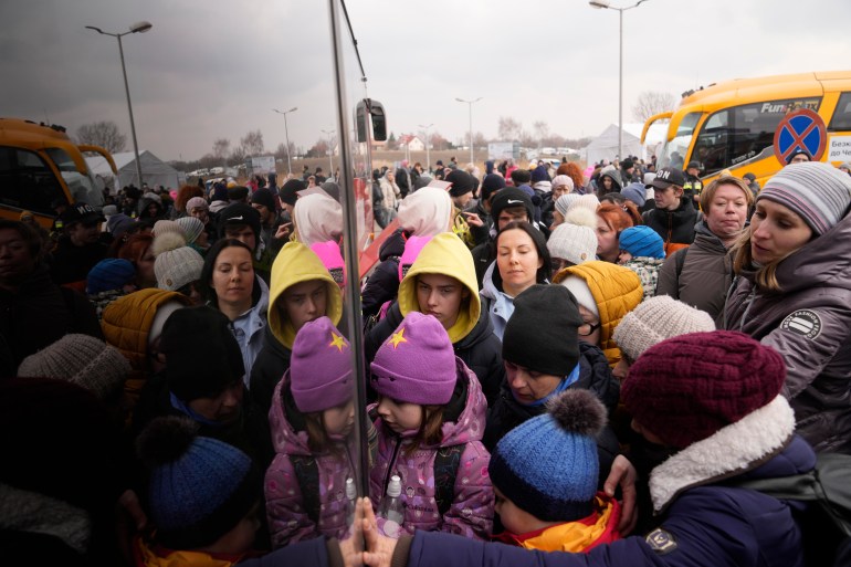 People fleeing from Ukraine queue to board a bus at the border crossing in Medyka, Poland on March 4, 2022