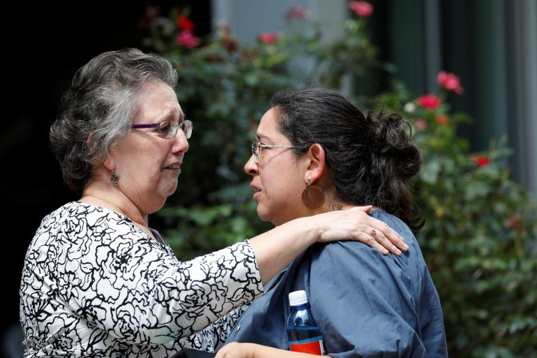 Women react outside the site of a school shooting in Uvalde, Texas.