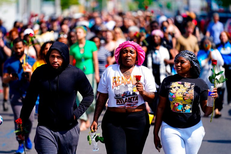 People march to the scene of a shooting at a supermarket in Buffalo, N.Y.