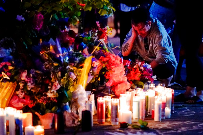 A person pays his respects at a candle vigil set up outside the scene of a shooting at a supermarket, in Buffalo.