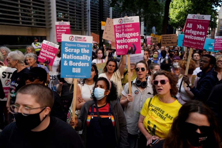 Protesters hold placards as they gather outside the Home Office in London