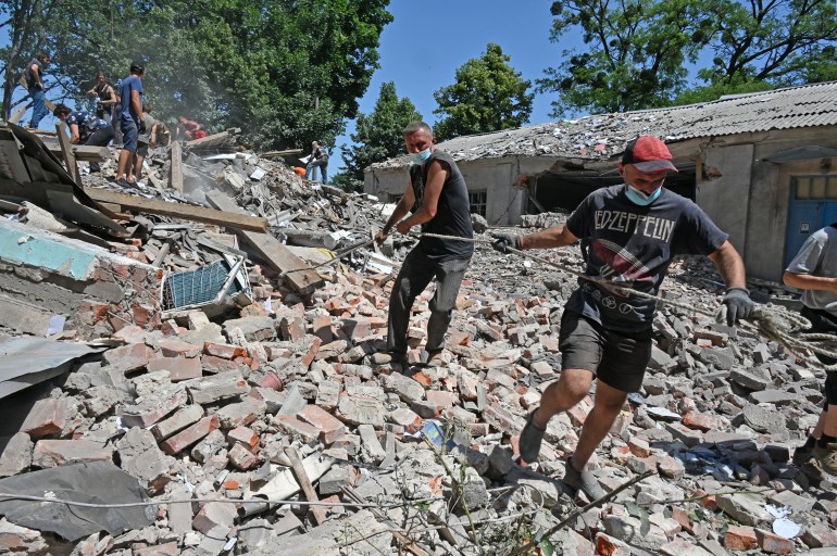 Employees of the Liubotinsky Lyceum of Railway Transport and local residents dismantle the ruins of an administrative building, as result of the explosion of a Russian rocket, in Lyubotyn, Kharkiv region, on June 20, 2022.