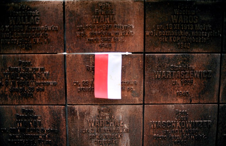 A Polish flag is seen on a wall inscribed with the names of Polish officers at the 1940 massacre memorial complex in Katyn. 