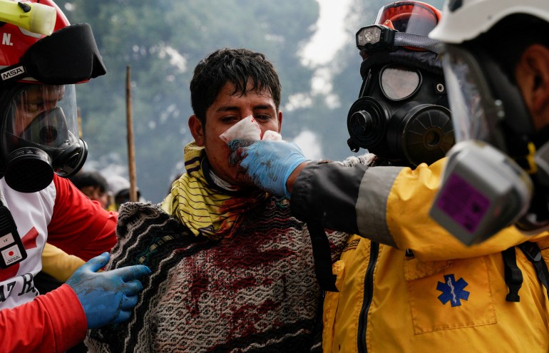 An injured demonstrator receives medical attention during an anti-government protest in Quito, Ecuador