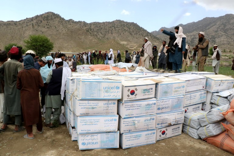 Afghan men gather to collect relief goods after a recent earthquake in Gayan.