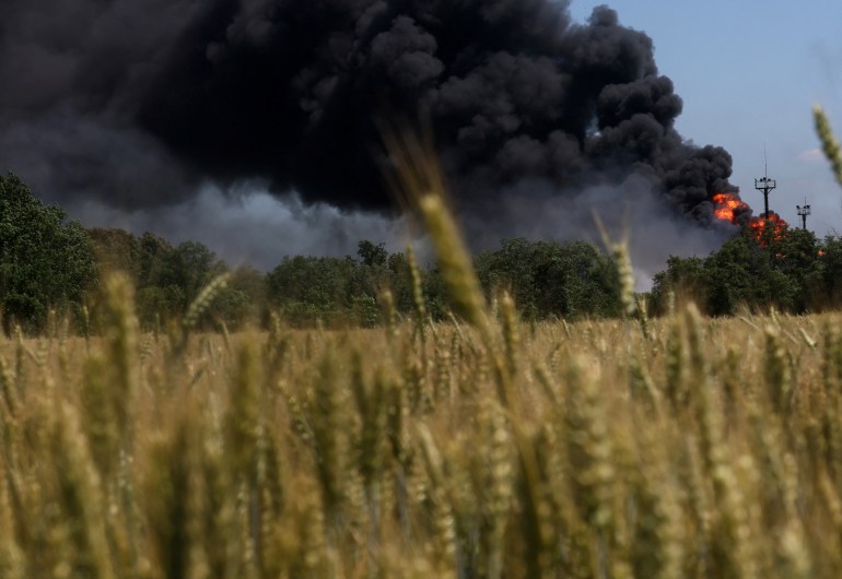 A fire from a gas processing plant continues to burn behind a field of wheat after the plant was hit by shelling a few days prior in Andriivka in the Kharkiv region, Ukraine June 21, 2022