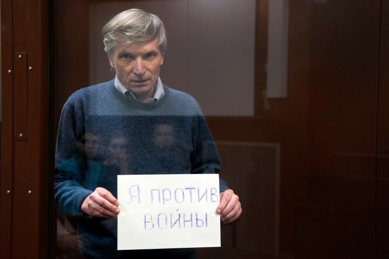 Alexei Gorinov holds a sign saying 
