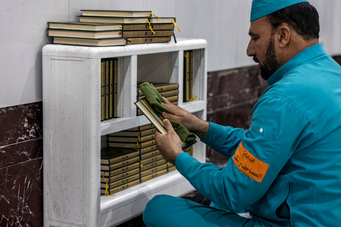 A worker at the Mecca Grand Mosque wipes copies of the Holy Koran