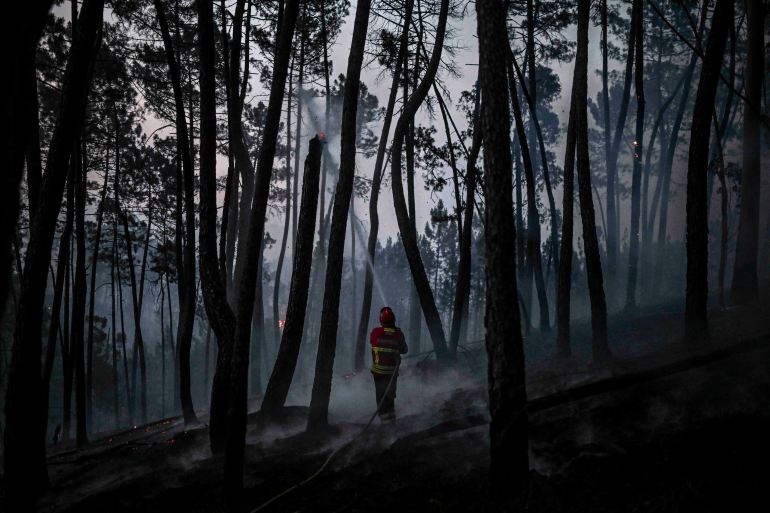 A firefighter works to extinguish a wildfire at Casais do Vento in Alvaiazere on July 10, 2022. - Around 1.500 firefighters were mobilized to put out three wildfires raging for more than 48 hours in central and northern Portugal
