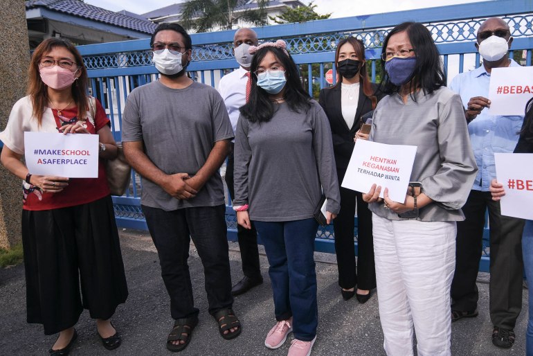 Malaysian teenager Ain Husniza, who reported her teacher for making a rape joke, speaks to the media supported by her father and supporters outside a police station 