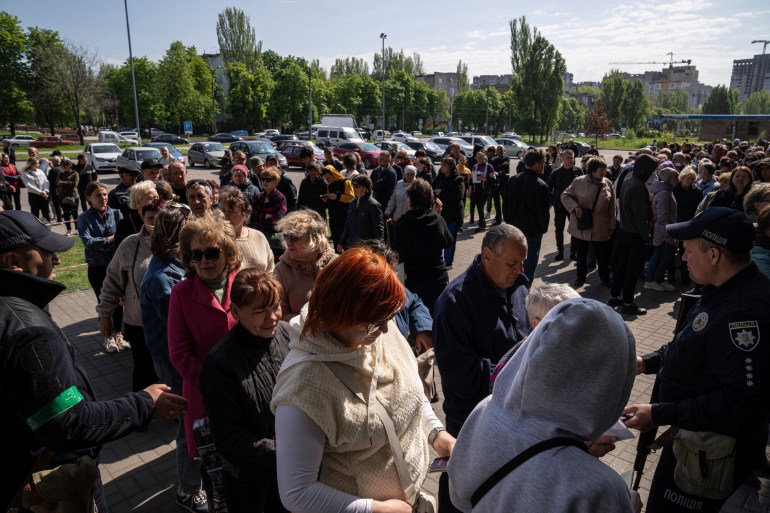 People stand in line for registration at the aid distribution center for displaced people in Zaporizhia, Ukraine