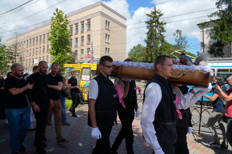 Men carry a coffin during a funeral ceremony for Liza, 4-year-old girl killed by Russian attack, in Vinnytsia, Ukraine