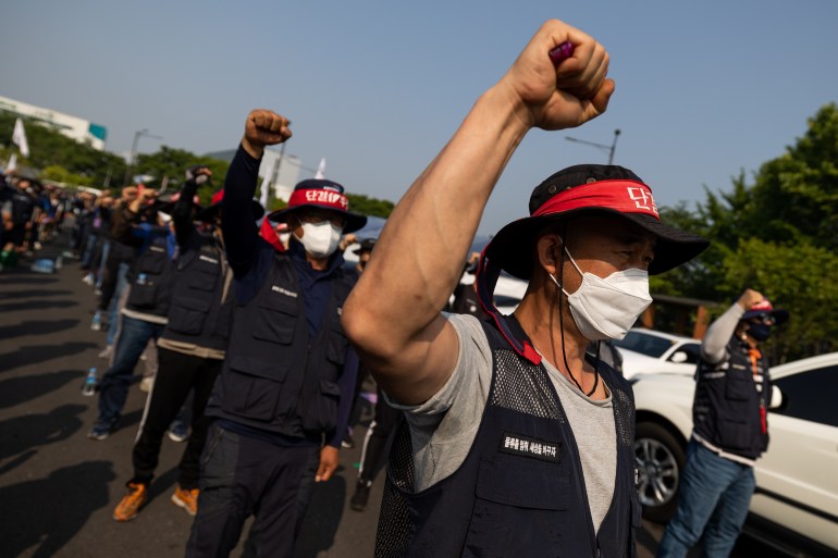 Truck drivers and members of the Korean Confederation of Trade Unions shout slogans during a demonstration in front of the Uiwang Inland Container Depot in Uiwang, South Korea, on Friday, June 10, 2022. Thousands of truck drivers who are seeking to prevent a change to wage rules have gone on strike at major ports and container depots, posing the latest threat to strained global-supply chains