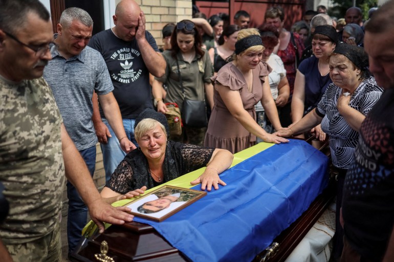Natalia, the wife of Ukrainian serviceman Volodymyr Kochetov, 46, who was killed in a fight during Russia's invasion, reacts during his funeral in the village of Babyntsi, Ukraine June 30, 2022 