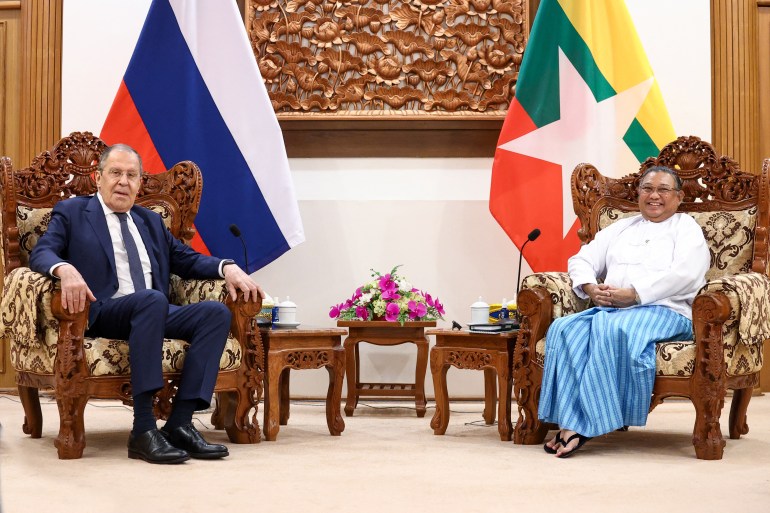 Russian Foreign Minister Sergey Lavrov and Myanmar Foreign Minister Wunna Maung Lwin sit together in large chairs with their respective national flags behind them.