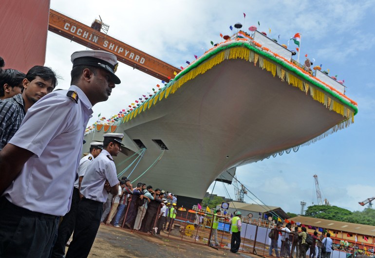 Indian naval officers stand guard during the launch of the indigenously-built aircraft carrier INS Vikrant