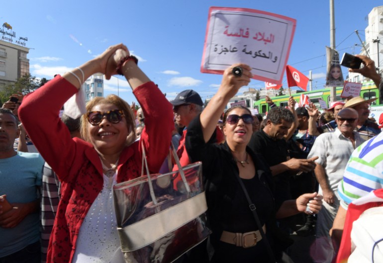 A supporters of the Tunisian Free Destourian Party raises a placard that reads in Arabic : 