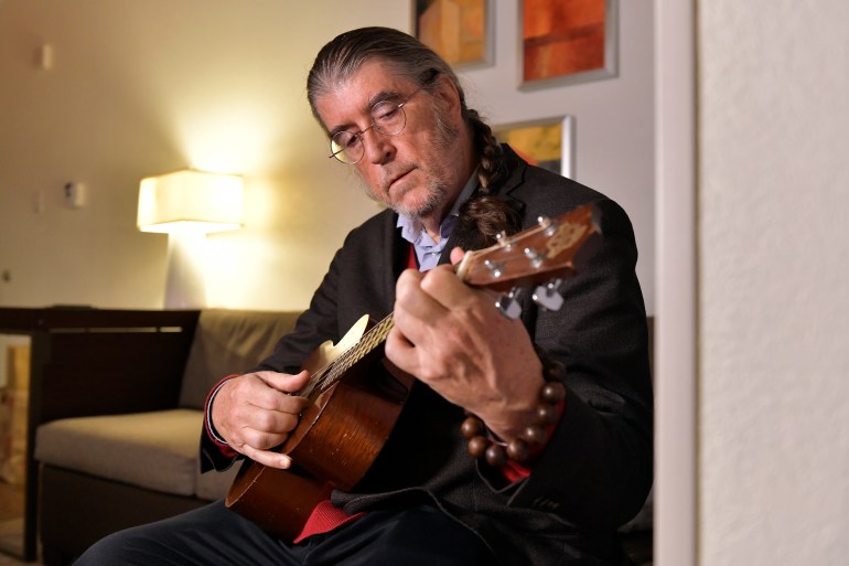 Philip H. Dybvig plays ukulele before an interview in a hotel, in Boston, after winning the 2022 Nobel Prize for Economics