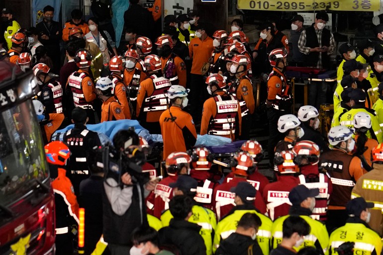 Dozens of rescue workers, firefighters and police officers are seen on the street near the scene of the stampede in Seoul, South Korea.